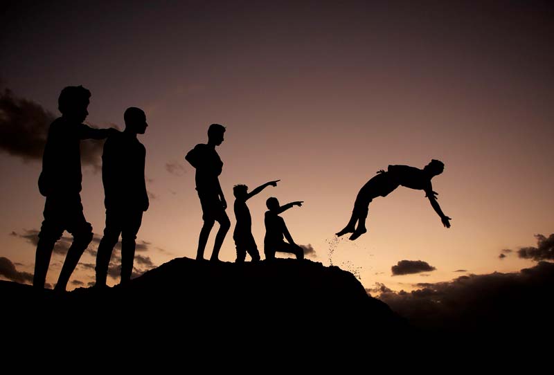 Palestinian youths practice parkour at sunset in Gaza City.-AFP photosn