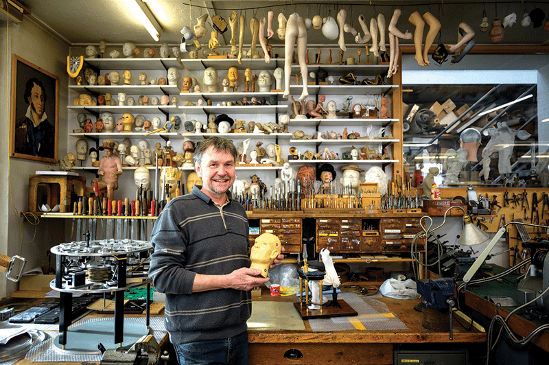 Swiss master Francois Junod posing with his tools and some heads used for the molding of parts of moving mechanical artworks, in his workshop in Sainte-Croix. -AFP photosn