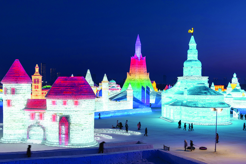 TOPSHOT - This photo taken on January 4, 2021 shows people looking at ice sculptures at the Harbin Ice and Snow Festival in Harbin, in northeastern China's Heilongjiang province on January 5, 2021. (Photo by STR / AFP) / China OUT