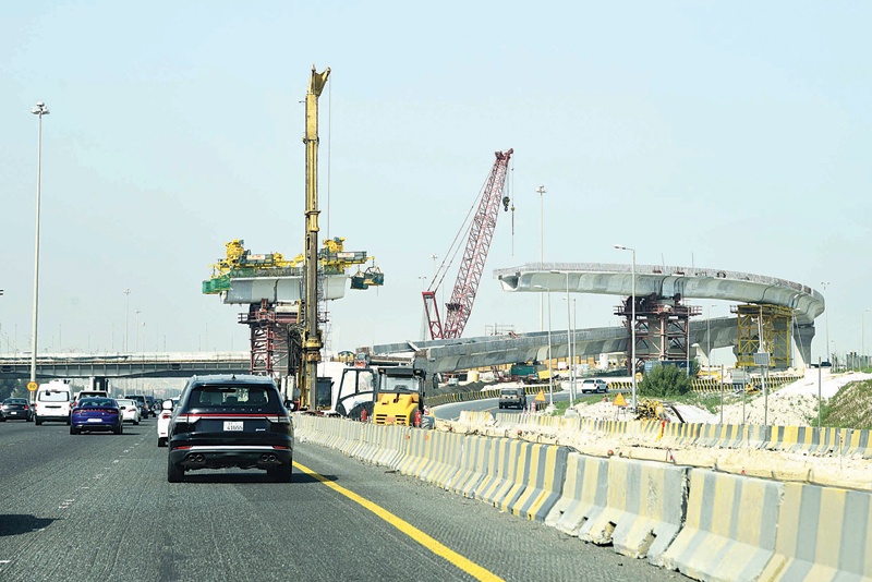 KUWAIT: Vehicles pass by a bridge under construction in Kuwait yesterday. - Photo by Fouad Al-Shaikhn