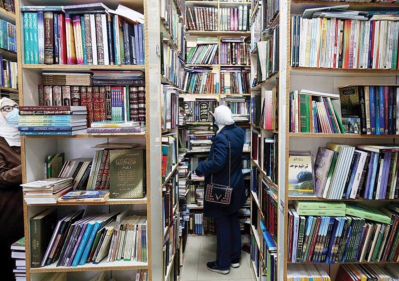 KUWAIT: A woman selects books at a bookstore in Kuwait City yesterday. - Photo by Yasser Al-Zayyat