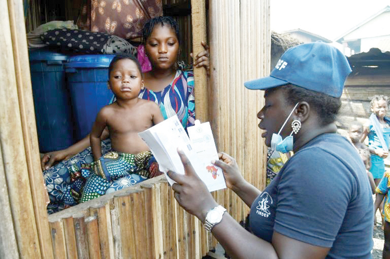 Bidemi Aye receives a pre-paid debt card for cash and food provided by the World Food Programme (WFP) in a makeshift home in the Makoko riverine slum settlement in Lagos.-AFPn