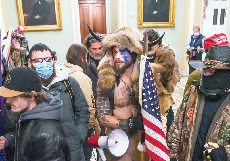 WASHINGTON, DC: In this file photo taken on January 06, 2021, supporters of US President Donald Trump, including Jake Angeli alias Jacob Anthony Chansley (center), a QAnon supporter, enter the Capitol in Washington, DC.  - AFPn