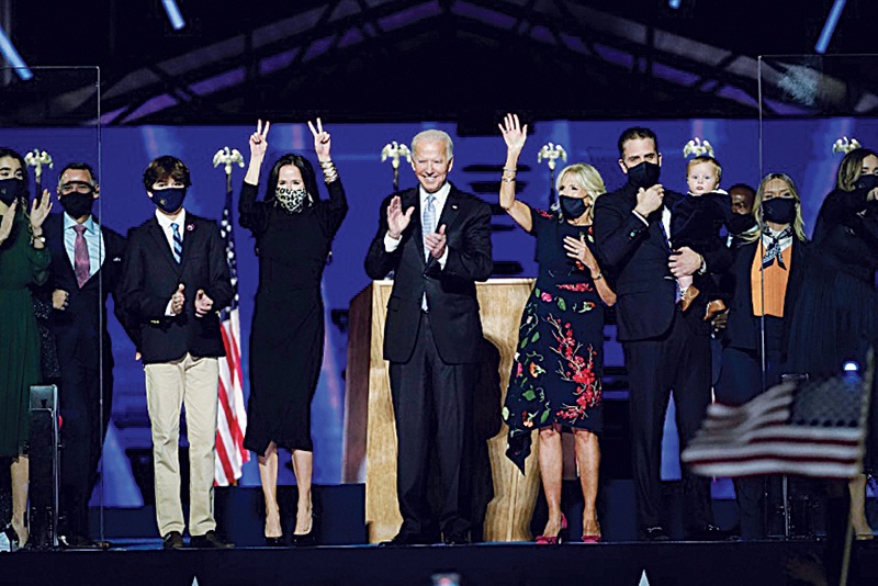 WILMINGTON, Delaware: US President-elect Joe Biden (center) with his wife Jill Biden and members of their family salute the crowd on stage after delivering remarks in Wilmington, Delaware in this November 7, 2020 file photon