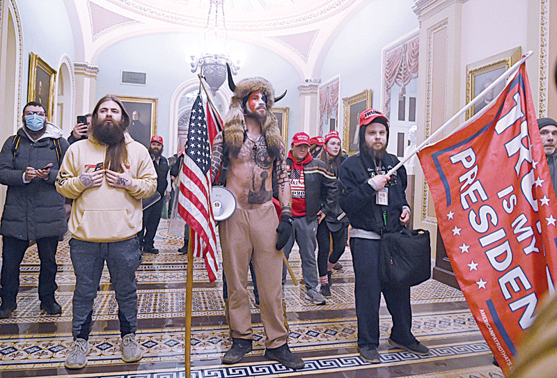 WASHINGTON: In this file photo supporters of US President Donald Trump, including member of the QAnon conspiracy group Jake Angeli, aka Yellowstone Wolf (center), enter the US Capitol, in Washington, DC.-AFP n