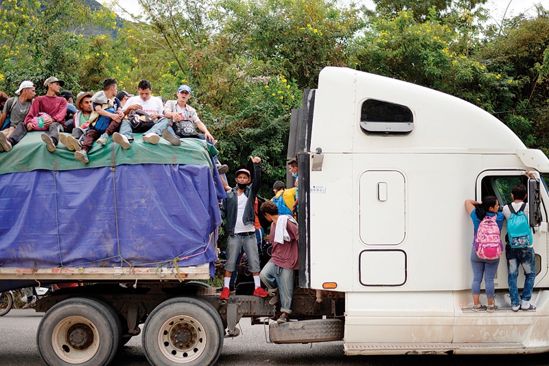 CAMOTAN, Guatemala: Honduran migrants, part of a caravan heading to the United States, hitchhike on a truck on Saturday. - AFP n