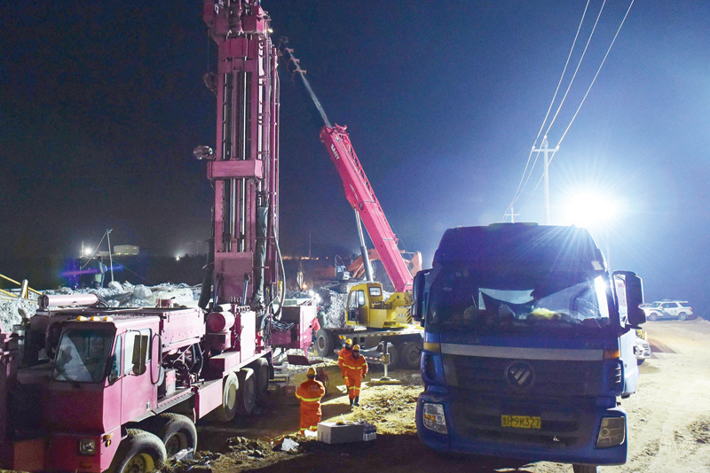 QIXIA, China: This photo shows rescuers working at the site of a gold mine explosion where 22 miners are trapped underground in Qixia, in eastern China's Shandong province.-AFPn