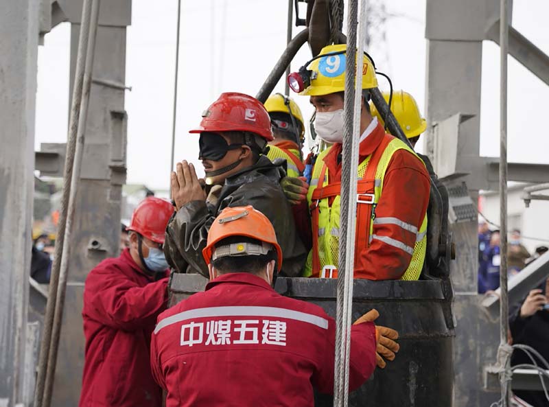QIXIA, China: One of twenty-two Chinese miners wearing a black patch is saved from hundreds of meters underground, in Qixia, in eastern China's Shandong province.-AFP n