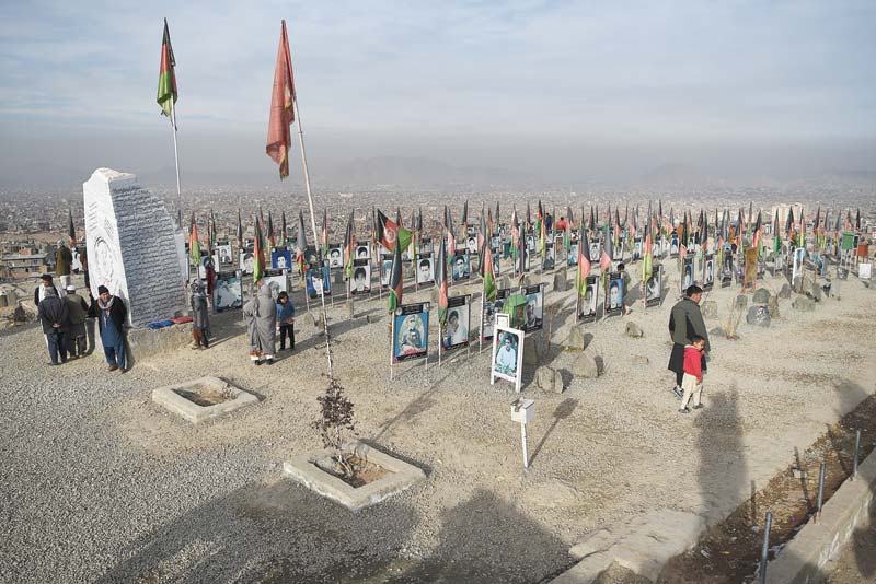KABUL: In this photo taken on January 14, 2021, Hazara men and women arrive to offer prayers for their relatives, members of the 'Enlightenment Movement', buried in a graveyard on the outskirts of Kabul. - AFPn