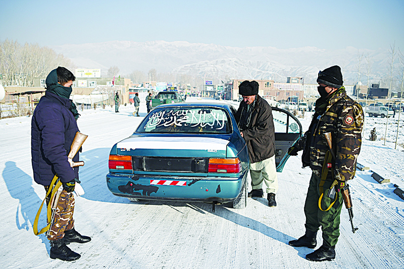Security personnel search a car at a checkpoint in the city of Bamiyan Province. A suicide bomber drove a vehicle loaded with explosives into a base for Afghan defense forces in the country's east yesterday, killing at least eight security personnel in an attack claimed by the Taleban.  - AFPn