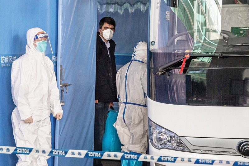 WUHAN: Vladimir G Dedkov (center), a member of the World Health Organization (WHO) team investigating the origins of the Covid-19 pandemic, boards a bus following the team's arrival yesterday.-AFP n