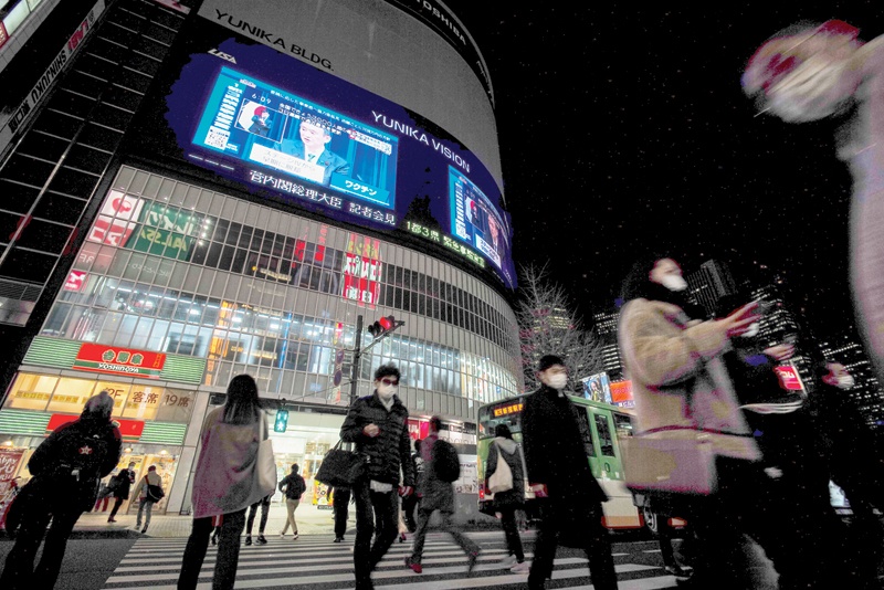 TOKYO: A large screen shows Japanese Prime Minister Yoshihide Suga during a live broadcast of a press conference on a state of emergency declared for the greater Tokyo area amid the COVID-19 coronavirus pandemic, in Tokyo yesterday.-AFPn