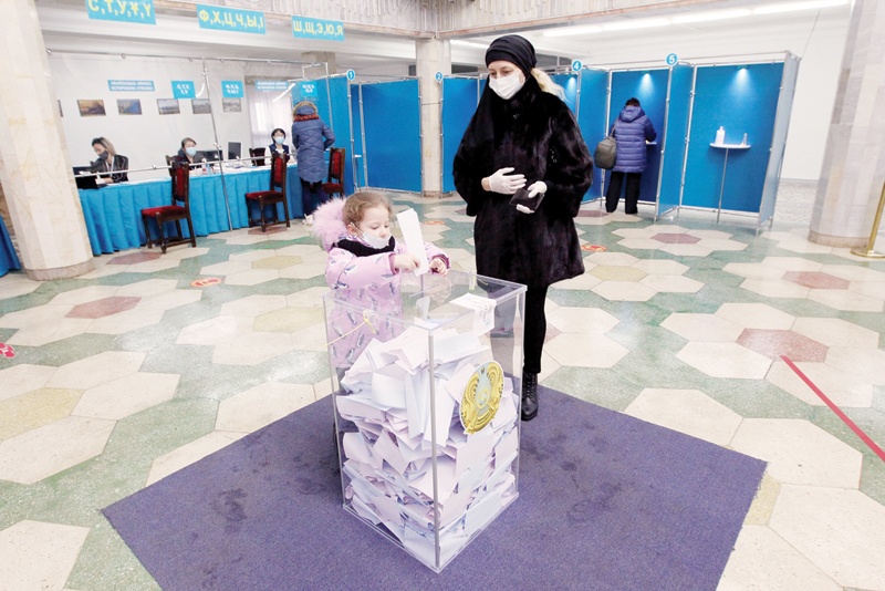 NUR-SULTAN: A woman with a child votes during Kazakhstan's parliamentary election in Nur-Sultan yesterday.-AFPnn
