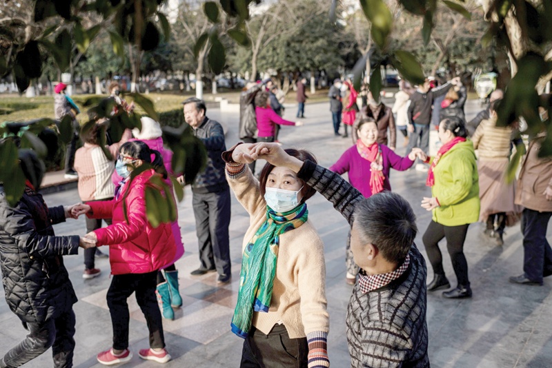 WUHAN: Elderly people dance in a public area along the Yangtze River in Wuhan yesterday as the city marks the first anniversary of when China confirmed its first death from the COVID-19 coronavirus. - AFPn