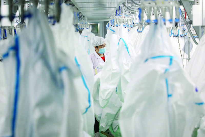 A worker checking protective suits at a workshop of a company which produces medical protective equipment in Jishou, in central China's Hunan province. - AFPnnn
