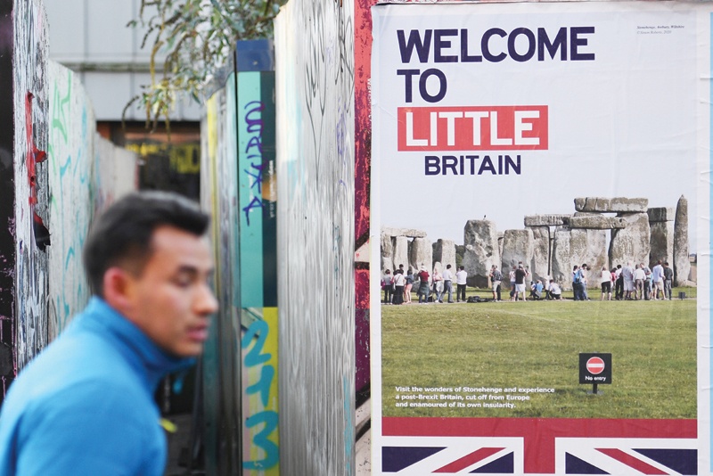 MANCHESTER: A pedestrian walks past an anti-Brexit poster in Manchester, north west England. - AFPn