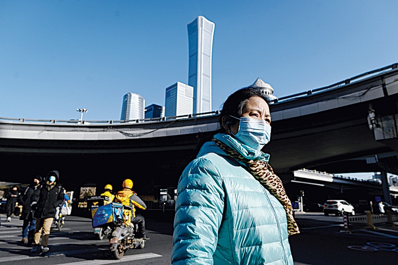 A woman crosses a street in the central business district (CBD) of Beijing yesterday.—AFPn