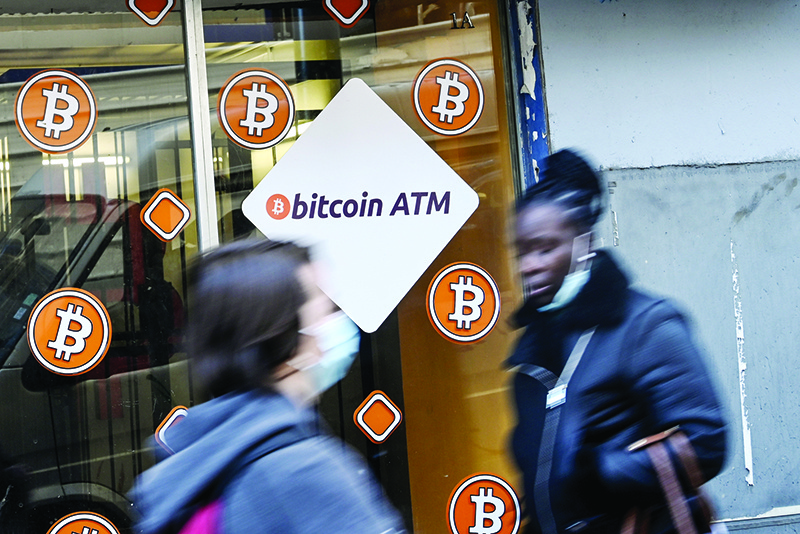 MARSEILLE: People walk past Bitcoin digital currency ATM shop in Marseille, southern France, on Friday. — AFP