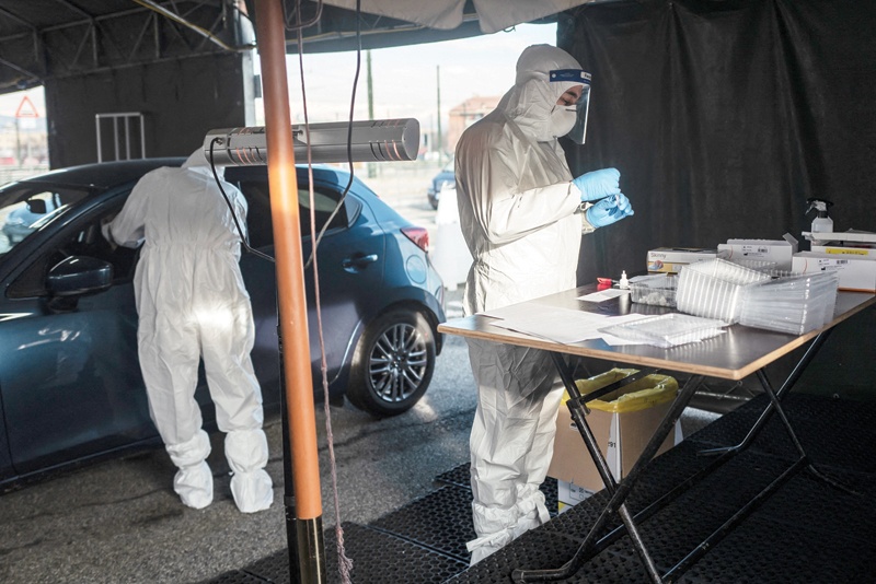 TURIN: Military medical workers collect swab samples yesterday at a drive-in testing center for COVID-19 set up by the Italian Army on the parking lot of the Juventus stadium in Turin, during the pandemic caused by the novel coronavirus. - AFPn