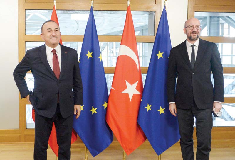 BRUSSELS: Turkish Foreign Minister Mevlut Cavusoglu (left) is welcomed by European Council President Charles Michel (right) before their meeting in Brussels.-AFP n