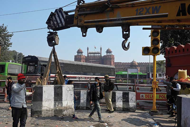 NEW DELHI: Workers set up a roadblock at the main entrance of the Red Fort yesterday, a day after farmers went on the rampage in the capital. - AFP nnn