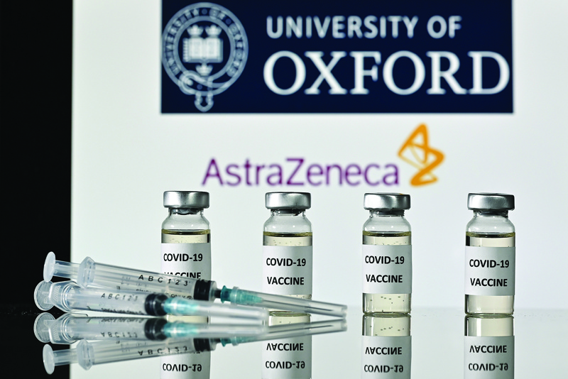This illustration photo shows COVID-19 vaccine vials and syringes with the logo of the University of Oxford and its partner, pharmaceutical company AstraZeneca. - AFP  n