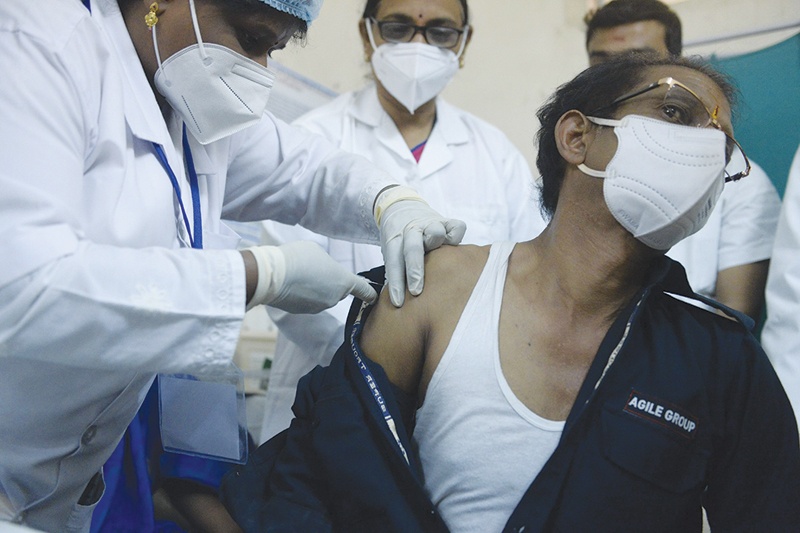HYDERABAD: A medical worker inoculates a security guard with a COVID-19 vaccine at King Koti Hospital yesterday. - AFP 