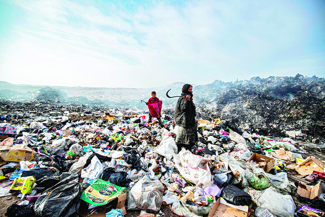 AL-MALIKIYA, Syria: Syrians sift through a garbage dump near an oilfield in the countryside of Malikiya on Jan 12, 2021. - AFP n