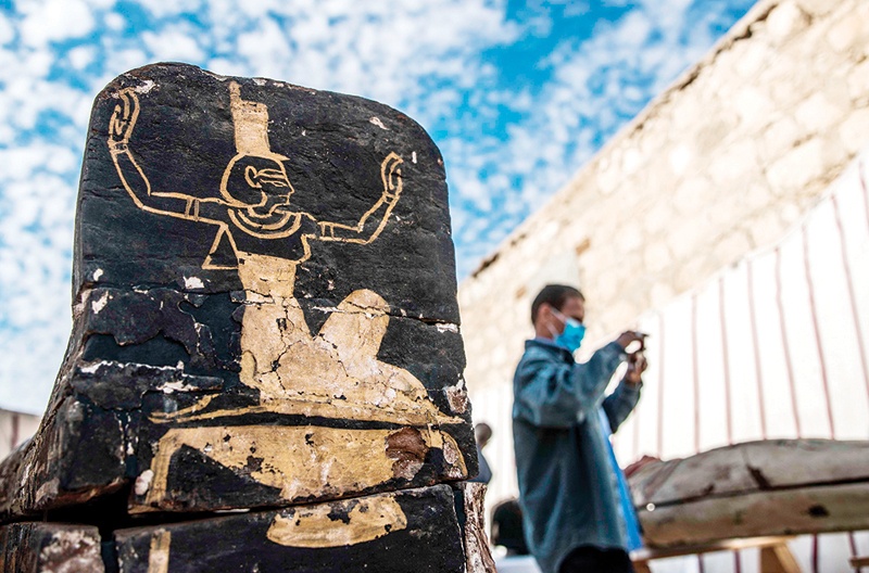 SAQQARA, Egypt: A visitor takes pictures next to an unearthed wooden coffin during the official announcement of the discovery of a new trove of treasures at Saqqara necropolis yesterday. - AFP