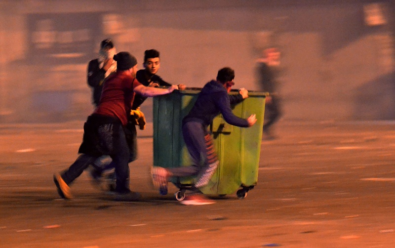 TRIPOLI, Lebanon:  Anti-government protesters push a dumpster during clashes following a demonstration against dire economic conditions in this northern Lebanese city on Monday. - AFP n
