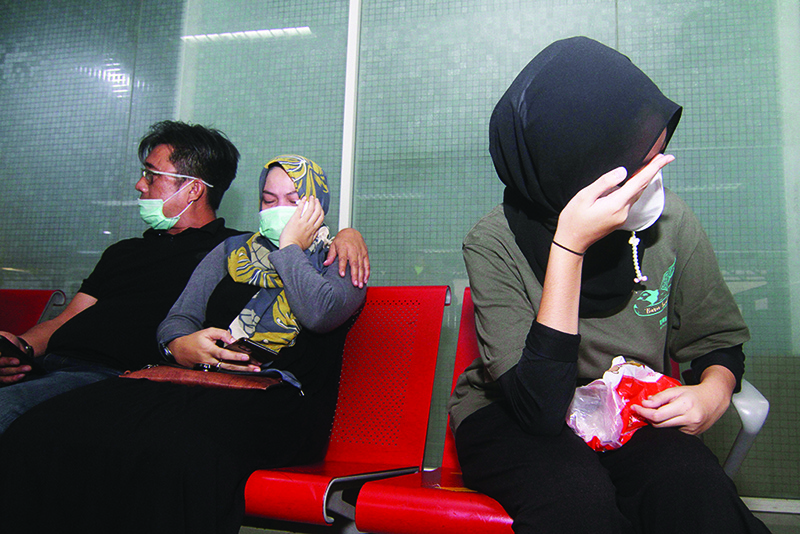 PONTIANAK, Indonesia: Relatives of passengers onboard missing Sriwijaya Air flight SJY182 wait for news at Supadio airport on Borneo island yesterday. —AFP