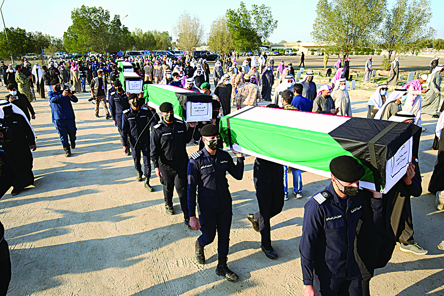 Kuwaiti security forces carry coffins of the martyrs to their final resting place.