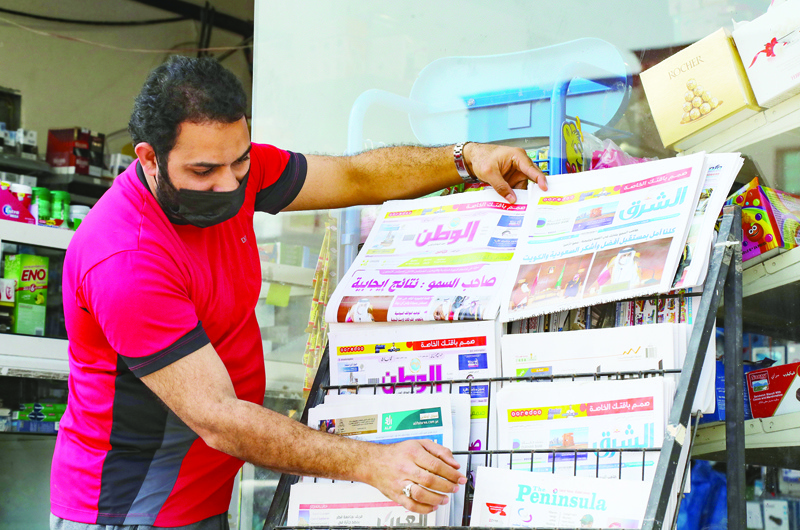 A man arranges newspapers on a stand outside a shop in the Qatari capital Doha showing headlines about the summit of the six-nation Gulf Cooperation Council (GCC) in the Saudi desert city of Al-Ula, on January 6, 2020, which saw Qatar's relations restored with Gulf nations. - Saudi Arabia and its allies have restored full relations with Qatar, Riyadh said yesterday after a landmark summit, ending a damaging rift that erupted in 2017.nFour nations, led by Saudi, cut ties and transport links with Qatar in June that year, alleging it backed radical Islamist groups and was too close to Riyadh's rival Iran -- allegations Doha denied. (Photo by KARIM JAAFAR / AFP)