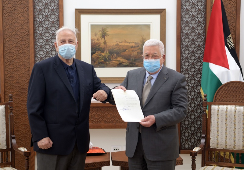RAMALLAH: A handout picture provided by the Palestinian Authority's press office (PPO) on Friday, shows Palestinian president Mahmud Abbas (right) handing the elections decree to the chairman of the central election committee Hanna Nasser, in the West Bank city of Ramallah. – AFPn