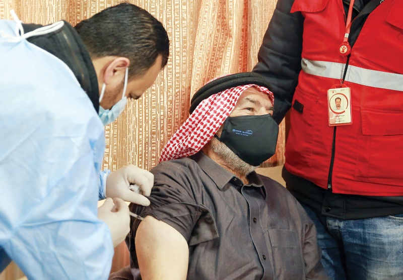MAFRAQ: A mask-clad Jordan-based Syrian refugee receives a vaccination dose against COVID-19 coronavirus disease at a governmental medical center in Mafraq in northern Jordan on Monday. - AFP
