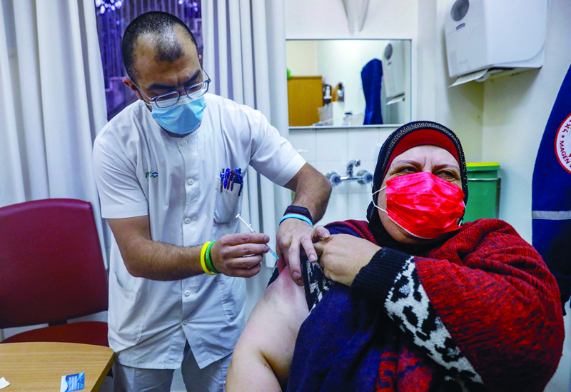 JERUSALEM: A Palestinian woman receives the Pfizer-BioNTech COVID-19 vaccine at the Clalit Health Services in the Israeli-annexed east Jerusalem.-AFP n