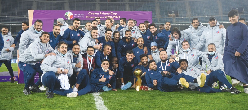 KUWAIT: Kuwait Sporting Club players pose with the HH the Crown Prince Cup after beating Qadsiya at Jaber Stadium yesterday. – Photo by Yasser Al-Zayyatn