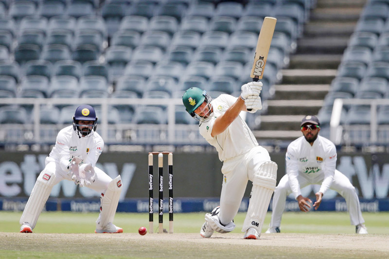 South Africa's Aiden Markram (C) watches the ball after playing a shot as Sri Lanka's wicketkeeper Niroshan Dickwella (L) looks on during the third day of the second Test cricket match between South Africa and Sri Lanka at the Wanderers stadium in Johannesburg on January 5, 2021. (Photo by PHILL MAGAKOE / AFP)
