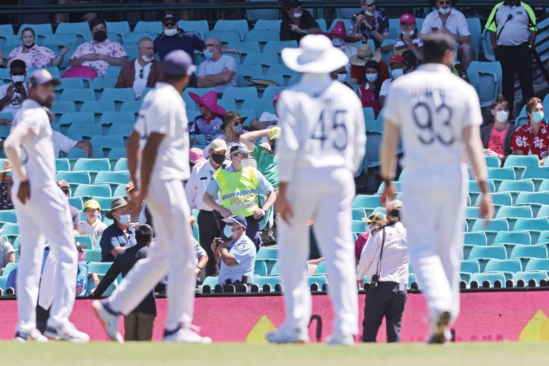 SYDNEY: A policeman (center) stands guard among sections of the crowd as the game was halted after allegedly some remarks were made by the spectators on the fourth day of the third cricket Test match between Australia and India at the Sydney Cricket Ground (SCG) in Sydney yesterday. - AFPn