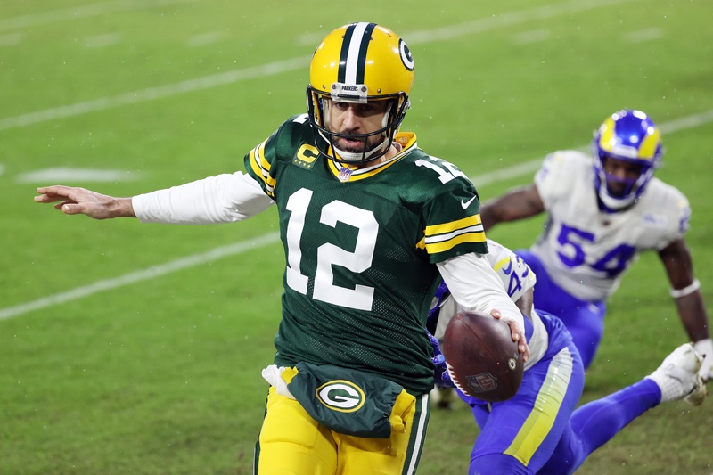 GREEN BAY: Aaron Rodgers #12 of the Green Bay Packers runs for a 1-yard touchdown in the second quarter against the Los Angeles Rams during the NFC Divisional Playoff game at Lambeau Field on Saturday in Green Bay, Wisconsin. – AFPn