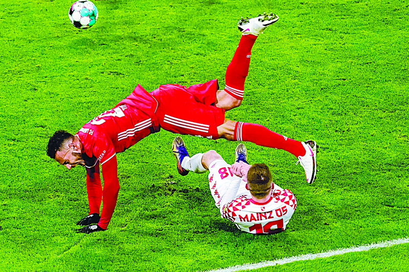 TOPSHOT - Mainz's German defender Daniel Brosinski (Bottom) fouls Bayern Munich's French midfielder Corentin Tolisso during the German first division Bundesliga football match FC Bayern Munich v Mainz 05 on January 3, 2021 in Munich, southern Germany. (Photo by G¸nter SCHIFFMANN / various sources / AFP) / DFL REGULATIONS PROHIBIT ANY USE OF PHOTOGRAPHS AS IMAGE SEQUENCES AND/OR QUASI-VIDEO