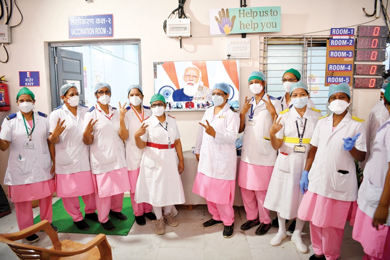 MUMBAI: Nurses from the Rajawadi Hospital make the victory sign gesture as they pose in front of antelevision broadcasting a live address by India's Prime Minister Narendra Modi before the start of the COVID-19 coronavirus vaccination drive in Mumbai yesterday. — AFPn