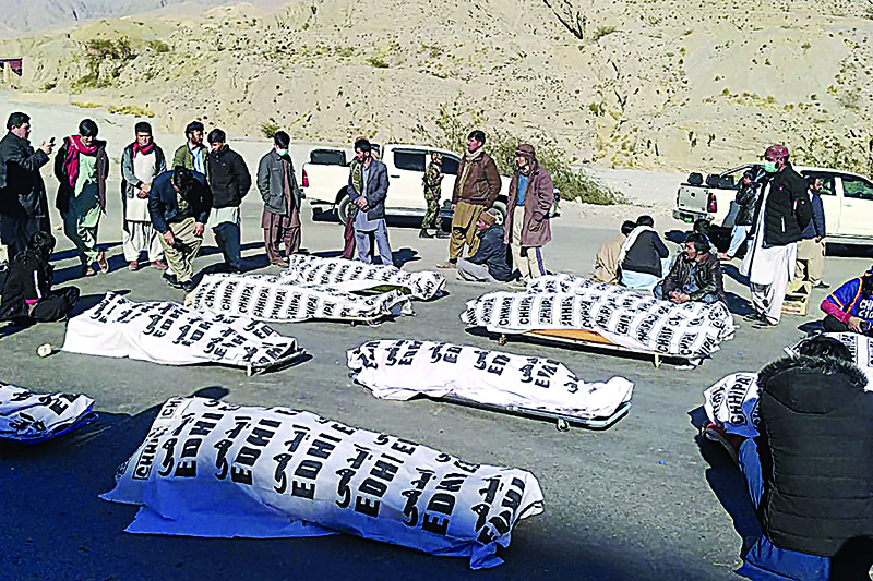 Members of Shiite Hazara community stand around the dead bodies after gunmen killed 11 workers of the community in mountainous Machh area, in the Balochistan province, on January 3, 2021. - Gunmen in southern Pakistan have killed at least 11 workers at a remote coal mine, officials said on January 3. (Photo by STR / AFP)