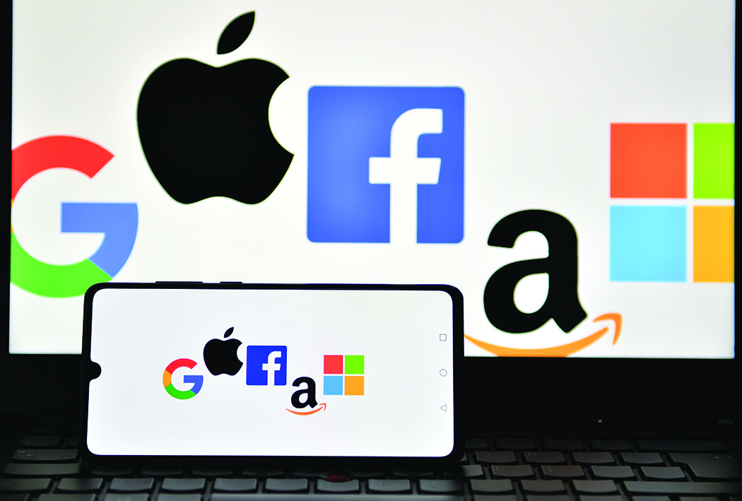 This file photo illustration picture taken in London shows the logos of Google, Apple, Facebook, Amazon and Microsoft displayed on a mobile phone and a laptop screen. - AFPn
