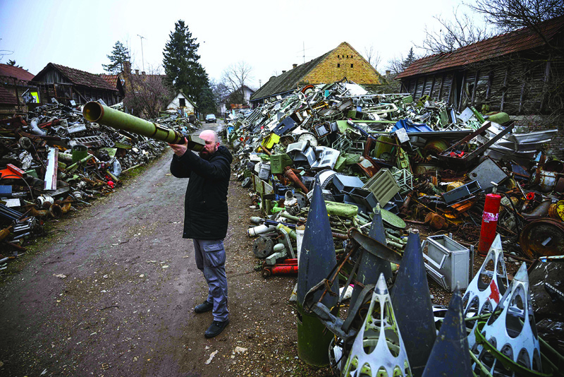 Serbian sculptor Nikola Macura browses through a military scrapyard, searching for weapons he could use as instruments in Temerin near Novi Sad.-AFP photosn