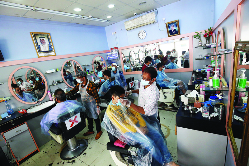 KUWAIT: Mask-clad customers get haircuts at a barber's shop in the capital Kuwait City yesterday, during the coronavirus pandemic crisis. - Photo by Yasser Al-Zayyatn