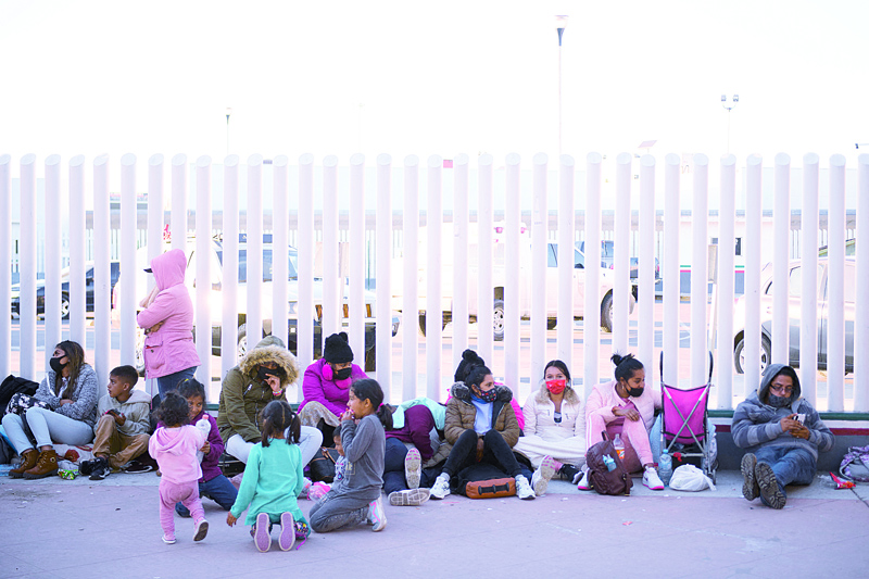 Asylum seekers wait outside the El Chaparral border crossing port as they wait to cross into the United States in Tijuana, Baja California state, Mexico on Friday.-AFPn