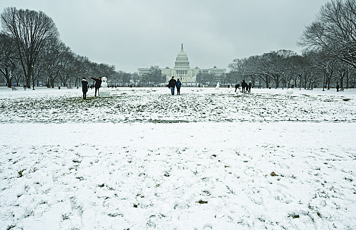 WASHINGTON, DC: People enjoy the snow dusted National Mall in Washington, DC not far from the US Capitol on Sunday as the capital region is under a winter storm warning through Monday night for an expected five or more inches (12.7 centimeters) of snow. - AFPn