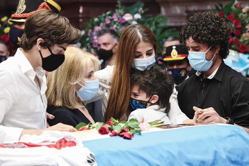 BUENOS AIRES: Handout picture released by the Argentine Senate showing Zulema Menem (center) and her sons Luca Bertoldi Menem (left) and Malek Pocovi Menem (center), her mother Zulema Yoma (second left) and her half-brother Carlos Nair Menem (right) mourning next to the coffin with the remains of late former Argentine president and senator Carlos Saul Menem, as he lies in state at the funeral chapel set at the Congress in Buenos Aires.-AFP n