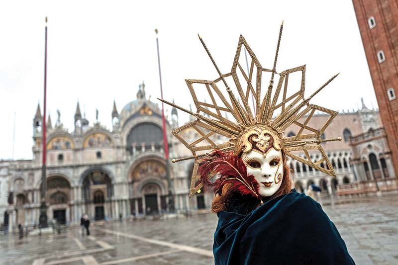 A Venetian artisan wearing a carnival mask and costume takes part in a demonstration of The Confederation of Venice Artisans (Confartigianato Venezia) at St Mark's square in Venice.-AFP photosn